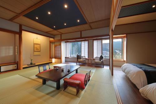 鹤冈市温海温泉橘屋的卧室配有一张床和一张桌子及椅子