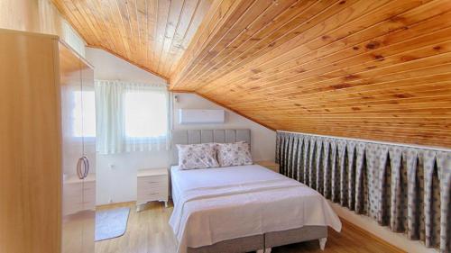 费特希耶Tanaydın Evleri的一间卧室设有一张床和木制天花板