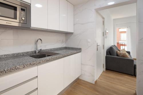 托雷德尔马尔Apartamento Torre del Mar的白色的厨房配有水槽和微波炉
