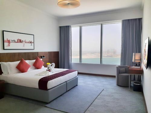 多哈多哈萨默塞特西湾公寓式酒店的酒店客房设有一张床和一个大窗户