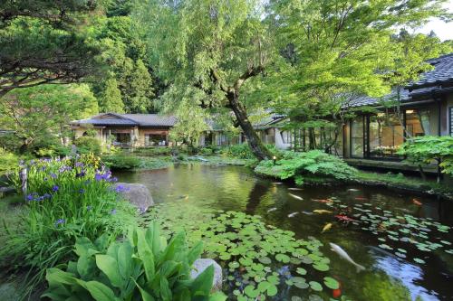 鹤冈市温海温泉橘屋的花丛和房子花园中的池塘