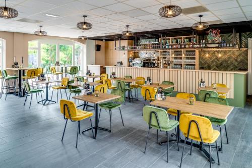 比塞尔Hoeve de Bongerd的餐厅设有木桌和黄色椅子
