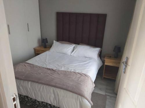 塞吉菲尔德Paradise Lake flats的一间卧室配有带白色床单和枕头的床。