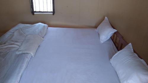 KhuriJaisalmer Safari Base & Camp的卧室内的一张带白色床单和枕头的床