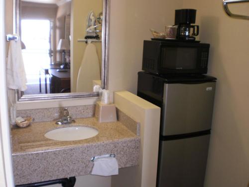 莫哈韦莫哈韦行政酒店的一间带水槽和微波炉的浴室以及一台电视。