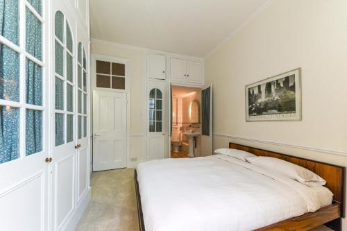 伦敦HydePark Queens Gate Apt的白色的卧室设有床和窗户
