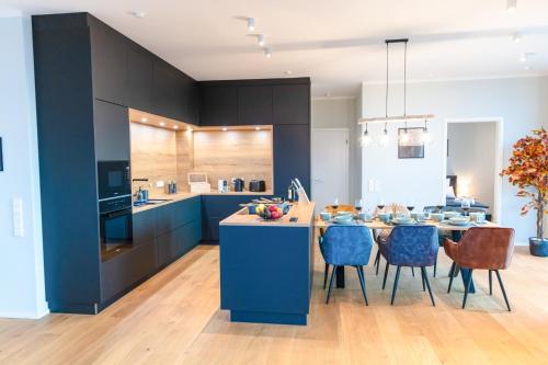 奥尔登堡CABANA - TheView - 10th Floor - Terrasse - Waterfront - Hafenviertel的厨房配有蓝色橱柜和桌椅
