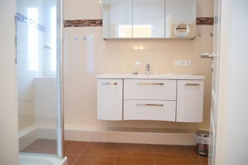 格洛米茨Haus Ostseeblick App 8 inkl WLAN的浴室配有白色水槽和淋浴。