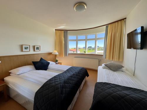 海德利桑德Adventure Hotel Hellissandur的酒店客房设有两张床和窗户。