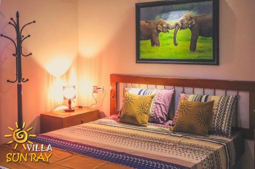 蒂瑟默哈拉默Villa Sun Ray的一间卧室,配有一张带两张大象照片的床