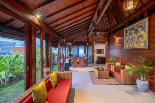 海神庙Nyanyi Sanctuary Villa by Ini Vie Hospitality的客厅配有红色沙发和黄色枕头