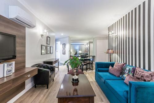 开普敦Romney Park Luxury Apartments的客厅配有蓝色的沙发和桌子