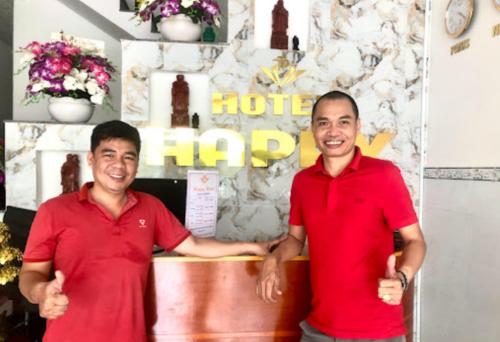 Bến CátHappy 1 Hotel Binh Duong的两个穿着红衬衫的人把 ⁇ 指伸出来