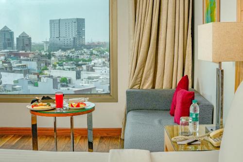 古尔冈古茹格拉姆市中心万怡酒店的一间带桌子的客厅,享有城市美景