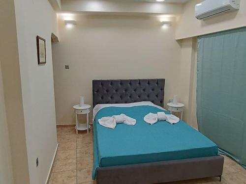 比雷埃夫斯Athens Sky Suites 1的一间卧室配有蓝色的床和毛巾