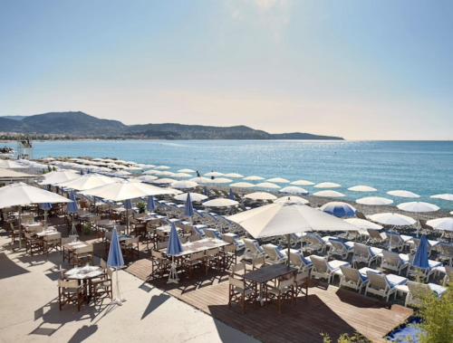 杜尔涅Voilier Love Nice的海滩上设有椅子和遮阳伞,还有大海