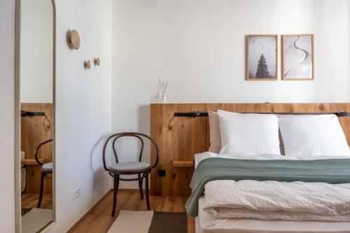弗利姆斯Casa Flurina的一间卧室配有一张带木制床头板和椅子的床。