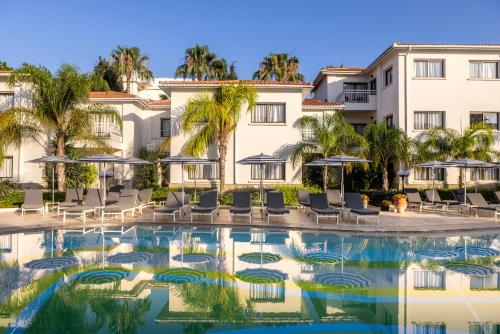 帕福斯King Jason Paphos - Designed for Adults by Louis Hotels的从游泳池欣赏到度假村的景色