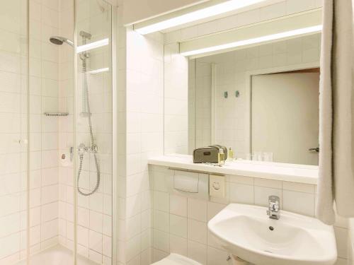 维也纳宜必思维也纳会展中心酒店的白色的浴室设有水槽和淋浴。