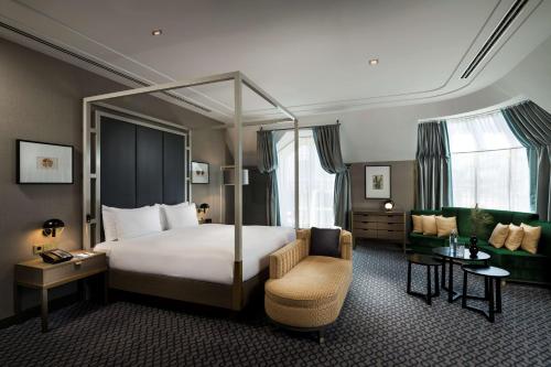 维也纳维也纳广场希尔顿酒店的配有一张床和一把椅子的酒店客房
