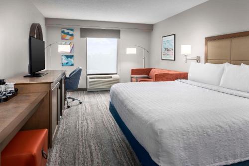 玛丽湖Hampton Inn & Suites at Lake Mary Colonial Townpark的配有一张床和一台平面电视的酒店客房