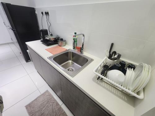 怡保The Horizon - Ipoh的厨房柜台设有水槽和碗架