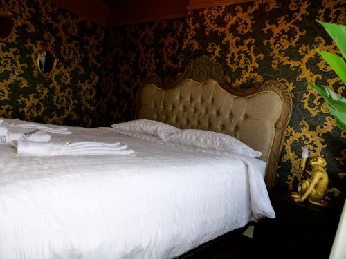 罗瑟勒姆Sexy Luxurious Versace Apartment Near Sheffield的一间卧室配有一张带金色框架的白色床