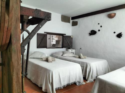 MáguezCasa Rural "La Molina"的白色墙壁客房的两张床