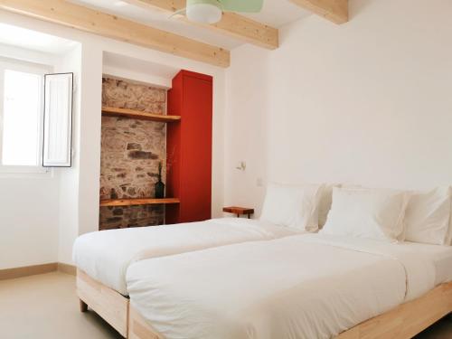 圣路易斯AL MAR Guesthouse的白色卧室设有两张床,设有红色的墙壁