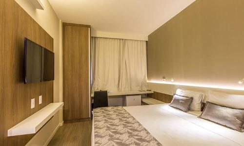 雅里努Alegro Hotel的配有一张床和一台平面电视的酒店客房