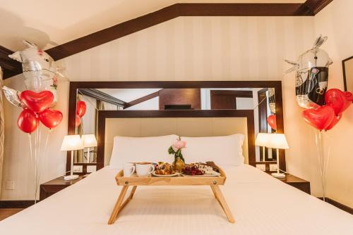 拉文纳帕拉兹贝兹酒店的一张带食物和气球盘的床