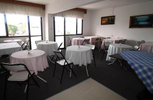 切什梅格伦酒店的配有桌椅和白色桌布的房间