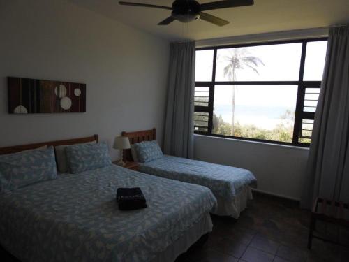 马盖特Marlicht Vacation Resort的一间卧室设有两张床和大窗户