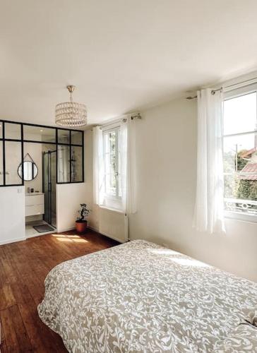 Deuil-la-BarreCharmante maison de ville proche Paris的一间白色卧室,配有床和2个窗户
