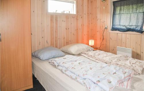 奥克斯伯尔Cozy Home In Oksbl With Wifi的卧室配有一张木墙内的大床