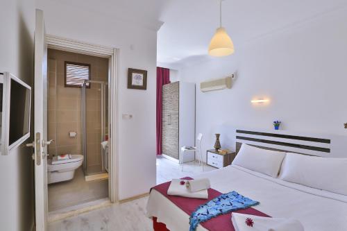 卡斯卡什库库卡奇酒店的一间白色卧室,配有床和一间浴室