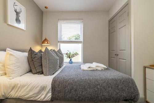德比Stay @ Baker Street Derby的卧室配有带枕头的床铺和窗户。
