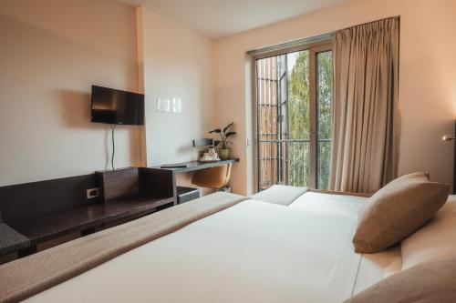 卡斯特努沃德加尔达Mod 05 Bike Hotel的卧室设有一张白色大床和一扇窗户。
