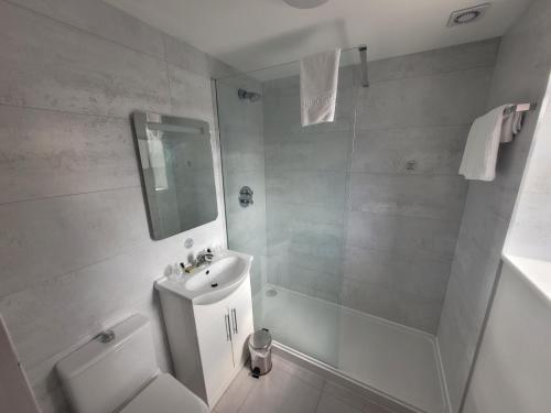 诺丁汉山毛榉休闲俱乐部酒店的白色的浴室设有水槽和淋浴。