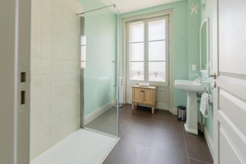 科涅克厄尔塔奇酒店的一间带玻璃淋浴和水槽的浴室
