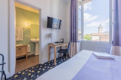 科涅克厄尔塔奇酒店的配有一张床、一张书桌和一扇窗户的酒店客房