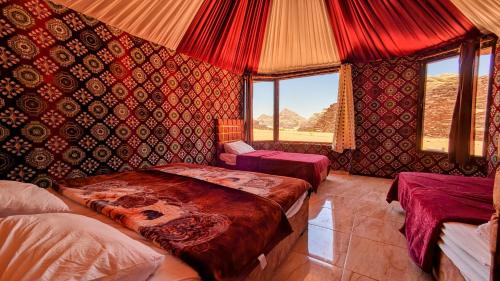 瓦迪拉姆WhyDesert Camp & Tours的一间设有两张床铺的卧室,位于带红色墙壁的房间