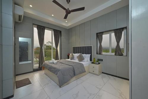 罗纳瓦拉Mountain Majesty Villa by Tropicana Stays的一间卧室配有一张床和吊扇