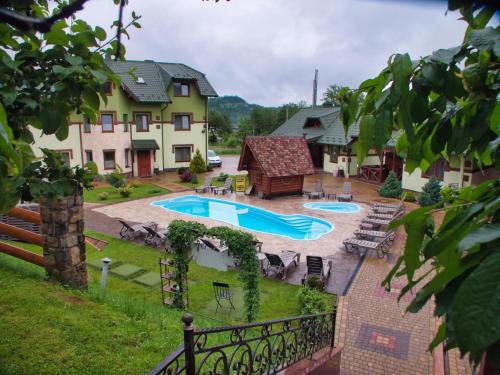 米库利钦Emerald House的一个带游泳池和房子的后院