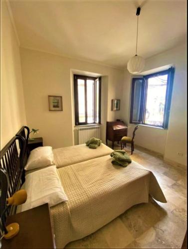 菲乌吉Casa Vittorio Emanuele的一间卧室设有两张床、一张桌子和窗户。