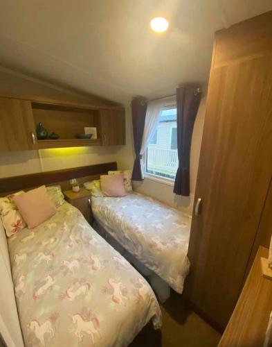 彭布罗克郡Tenby - Kiln Park caravan hire的一间小卧室,配有两张床和窗户