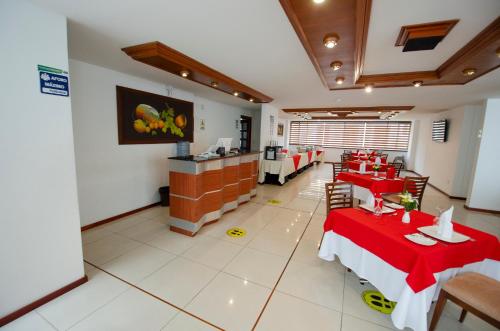 帕斯托奎利亚尔斯酒店的餐厅设有红色的桌椅和柜台