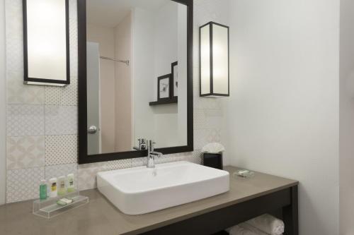 EnidCountry Inn & Suites by Radisson, Enid, OK的浴室设有白色水槽和镜子