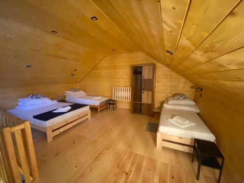 HoryniecApartamenty Domek na Roztoczu的小木屋内带两张床的房间