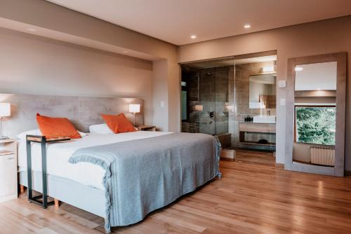圣卡洛斯-德巴里洛切Basia Hotel & Sushi的一间卧室配有一张带橙色枕头的大床